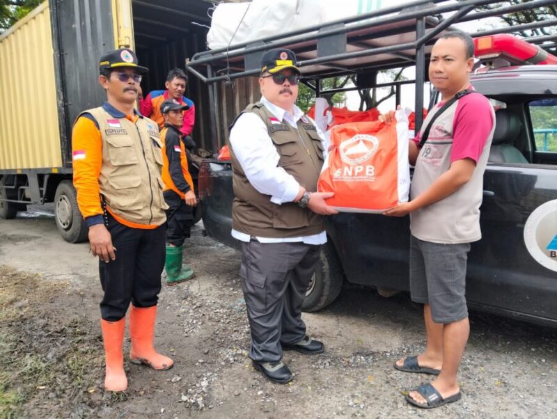 BANTUAN-Kepala Pelaksana BPBD Demak, Agus Sukiyo saat memberikan bantuan kepada salah satu korban terdampak banjir di Demak. (Foto Ist).
