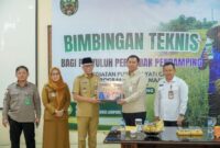 Gubernur Lampung didampingi Kepala Dinas KPTPH Provinsi Lampung  menyerahkan bantuan paket Pupuk Hayati Cair (PHC) secara simbolis pada acara Bimbingan Teknis bagi Penyuluh Pertanian Pendamping di Aula Bapelkes Lampung