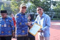 Achmad Dimyati Natakusumah menyerahkan sertifikat penghargaan secara simbolis kepada salah satu perwakilan penggiat koperasi pada Apel Peringatan Hari Koperasi Nasional Ke-79