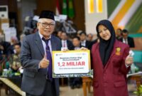 Foto Anggota BPH UMY, Prof. Dr. H. Mundzirin Yusuf, M.Si menyerahkan secara simbolis beasiswa Dokter dan Dokter Gigi Muhammadiyah kepada Alfina Rohmah (Fina)