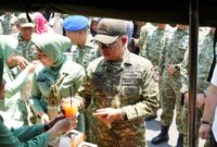 Panglima TNI Jenderal TNI Agus Subiyanto menerima minuman dari salah satu stan bazar yang dikelola persit dan keluarga besar TNI di Halaman Balai Pamungkas, Yogyakarta.