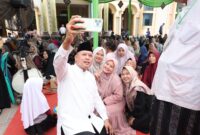 Wali Kota Bekasi Tri Adhianto berswafoto bersama jamaah dan warga Mustikajaya di sela tabligh akbar peringatan Maulid Nabi Muhammad SAW di Masjid Jami Al-Khairiyah, Minggu (27/9/2026).