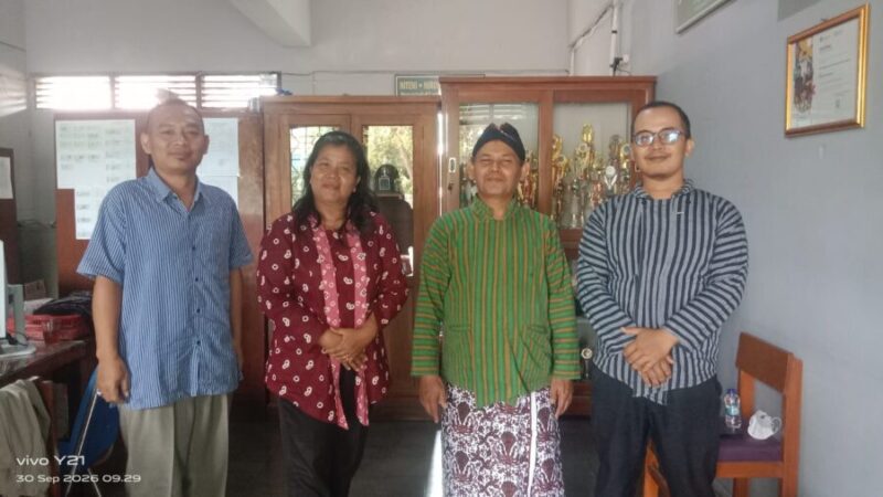 Kepala SMP Taman Dewasa Ibu Pawiyatan Ki Rosidi (second right, berbusana adat lurik hijau) berfoto bersama jajaran guru pendamping di lingkungan sekolah, Yogyakarta
