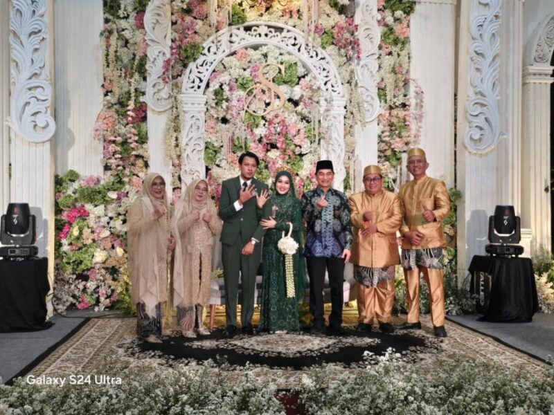 Wagub Banten Achmad Dimyati Natakusumah berfoto bersama kedua mempelai, Prasasti Dwi Eka Pertiwi dan Muhammad Syahid Fatah Nugroho, beserta keluarga besar di atas pelaminan.
